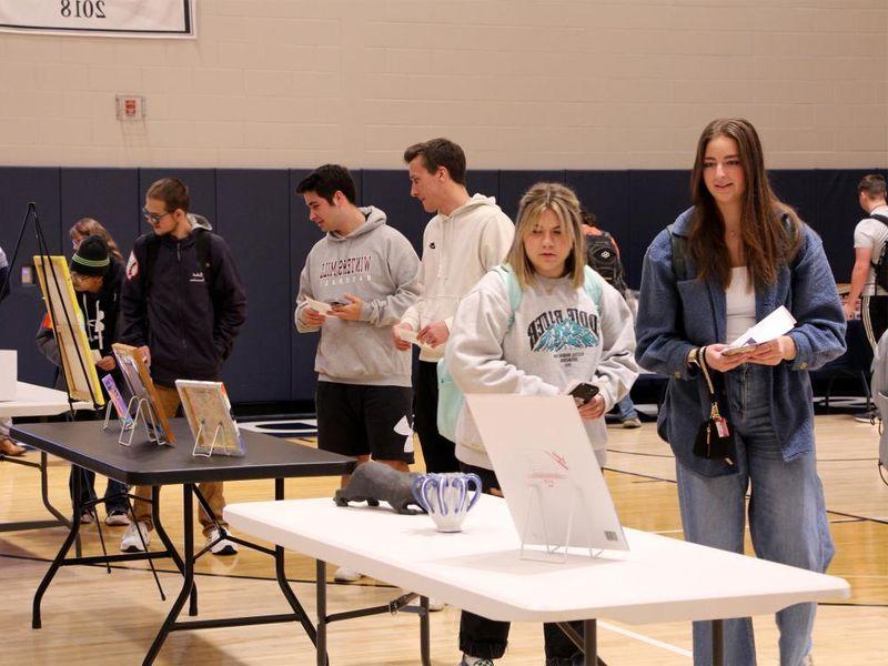 Attendees view some of the artwork submitted at the annual campus and community art show, hosted by the IDREAM Team at Penn State DuBois.